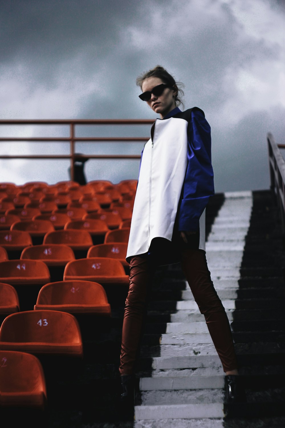 woman in blue coat standing on the road