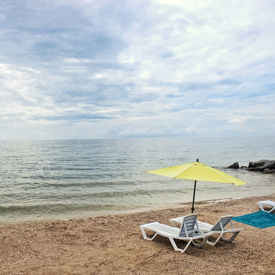 white and blue beach chair on beach shore during daytime