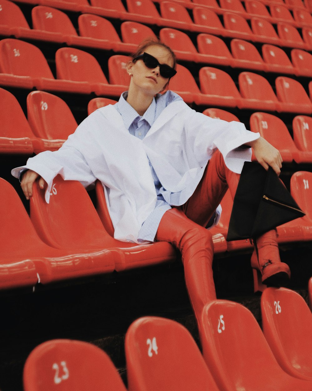 man in white dress shirt and red pants sitting on red chair