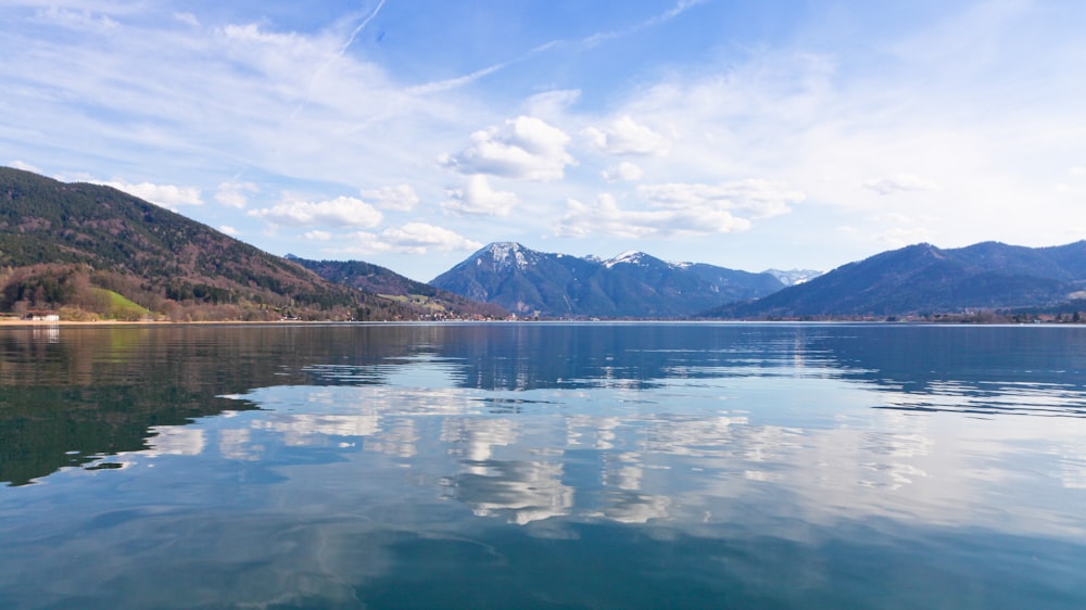 body of water near mountain under blue sky during daytime