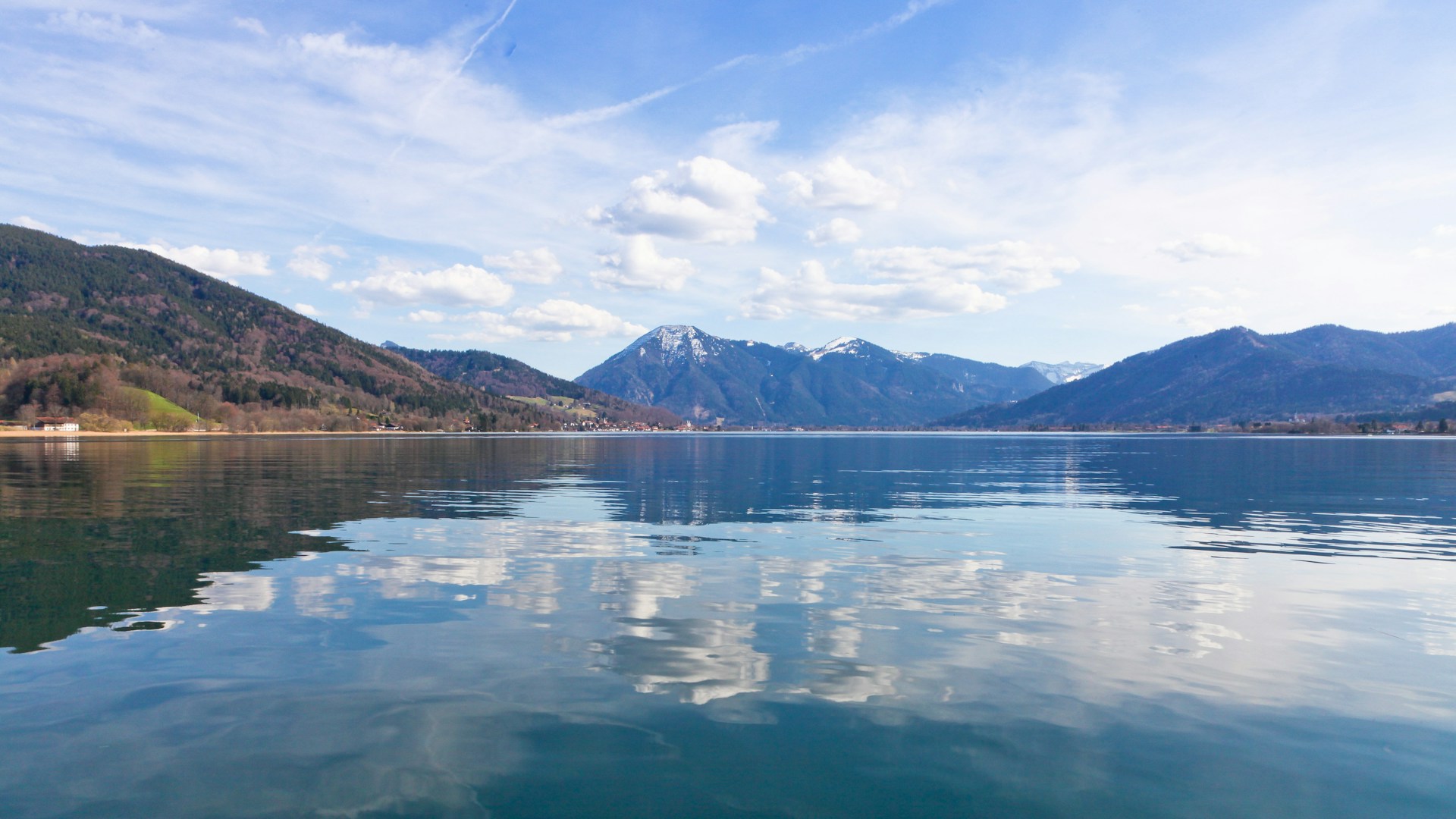 body of water near mountain under blue sky during daytime