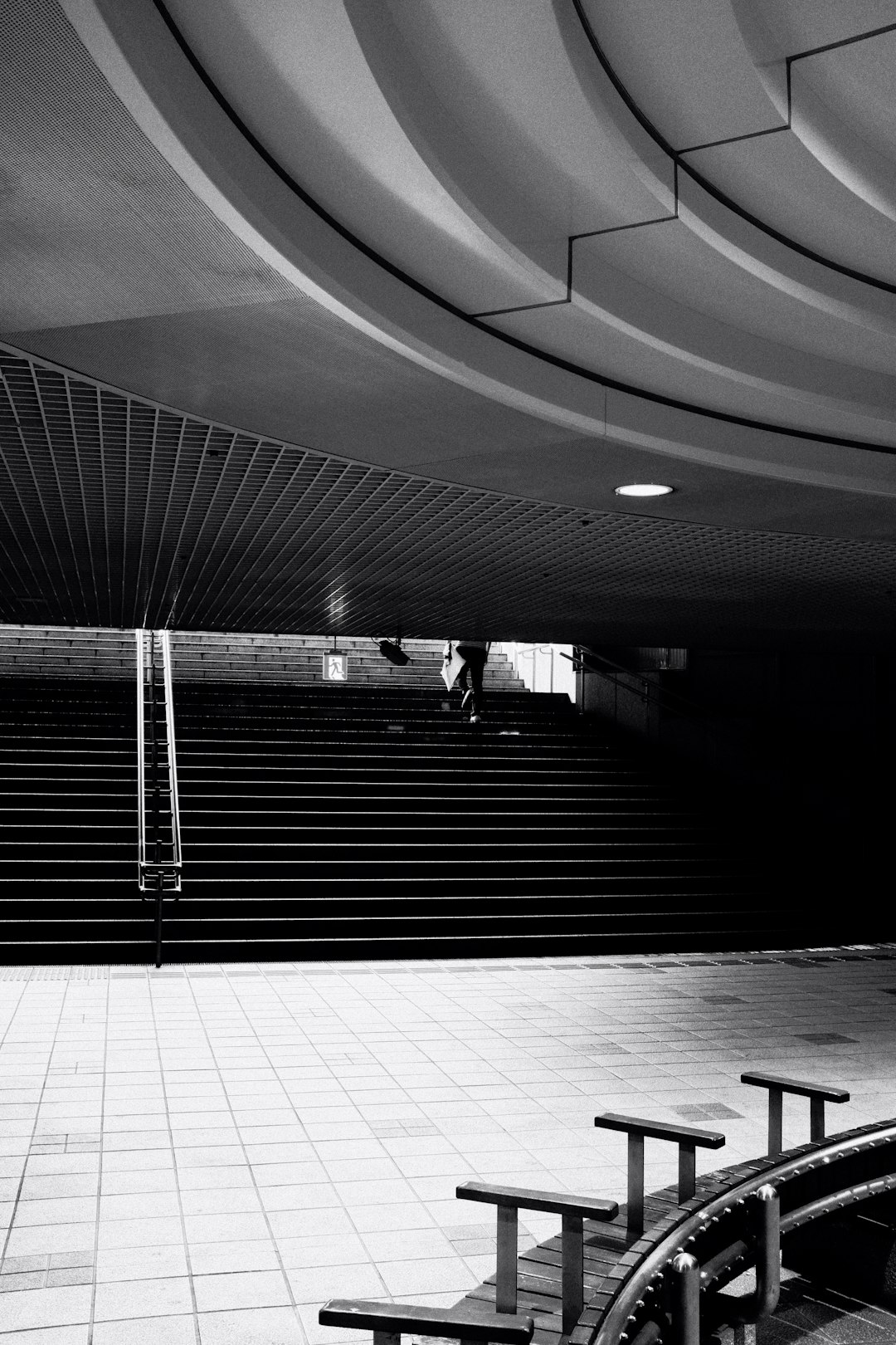 grayscale photo of people walking on a tunnel