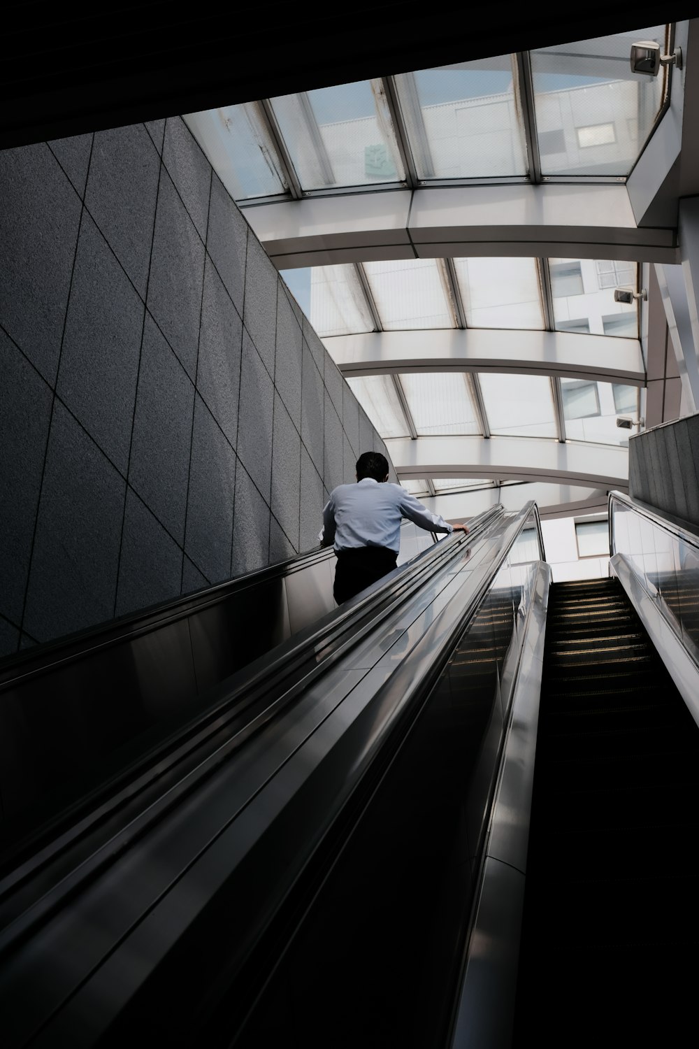 man in white shirt and black pants walking down the stairs