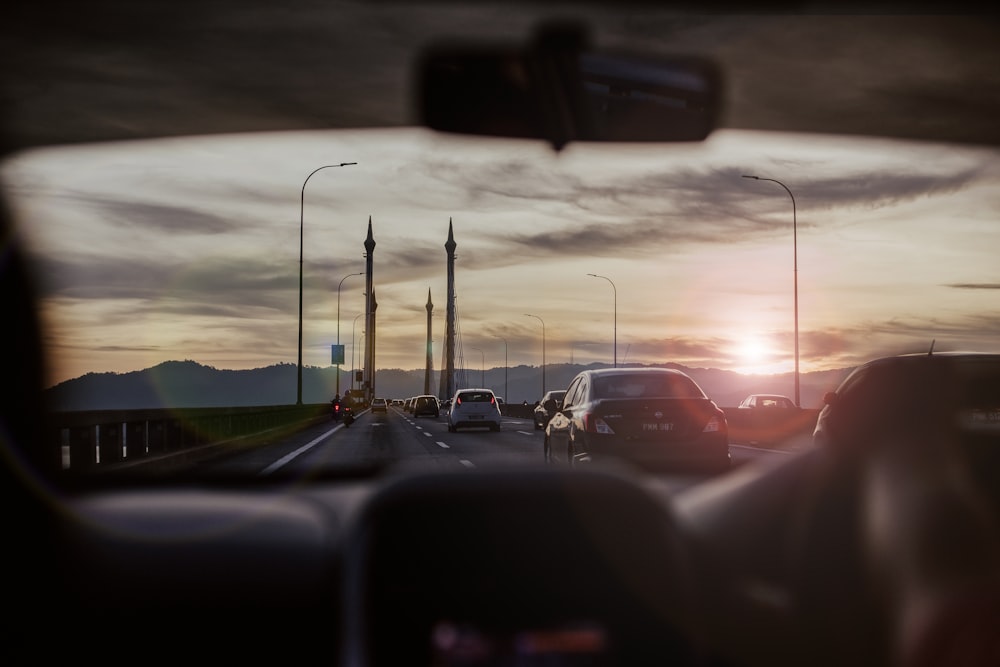 Coches en la carretera durante la puesta de sol