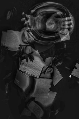 A swirling motion created by a pair of hands in the center gives the impression of manipulating energy or air. Surrounding the hands, multiple pages filled with text float effortlessly in a dark space, intertwining with abstract elements and subtle plant-like textures.