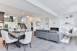 A dining table and grey sofa in an open plan living room