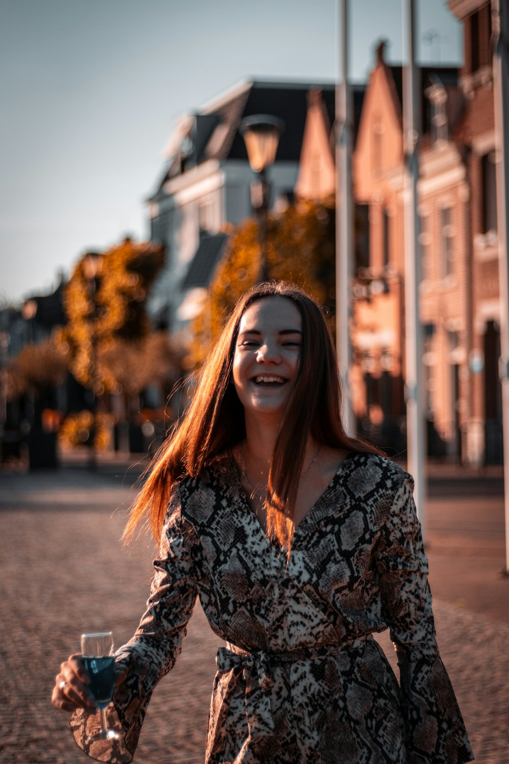 woman in black and white floral long sleeve shirt standing on road during daytime