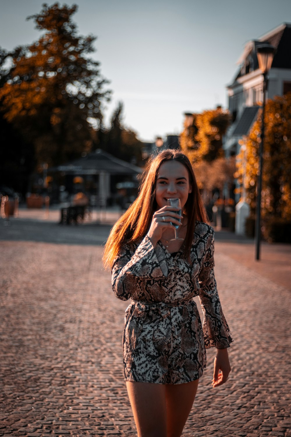 woman in black and white floral long sleeve shirt standing on road during daytime