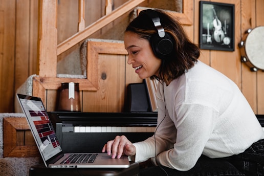 A student studying on a laptop in a cozy home setting, headphones on.