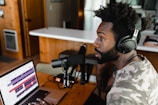 man in camouflage shirt sitting in front of laptop computer