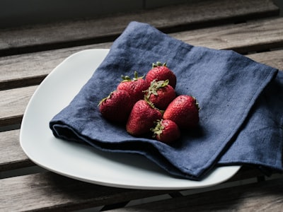 red strawberries on blue textile napkin teams background