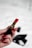 A close-up of a hand holding a vibrant lipstick against a softly lit background.