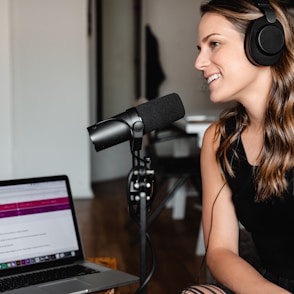 woman in black tank top sitting on chair in front of microphone