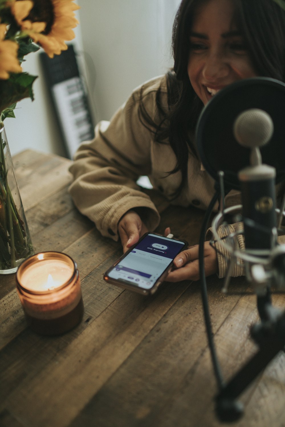 personne en veste marron à l’aide d’un smartphone noir