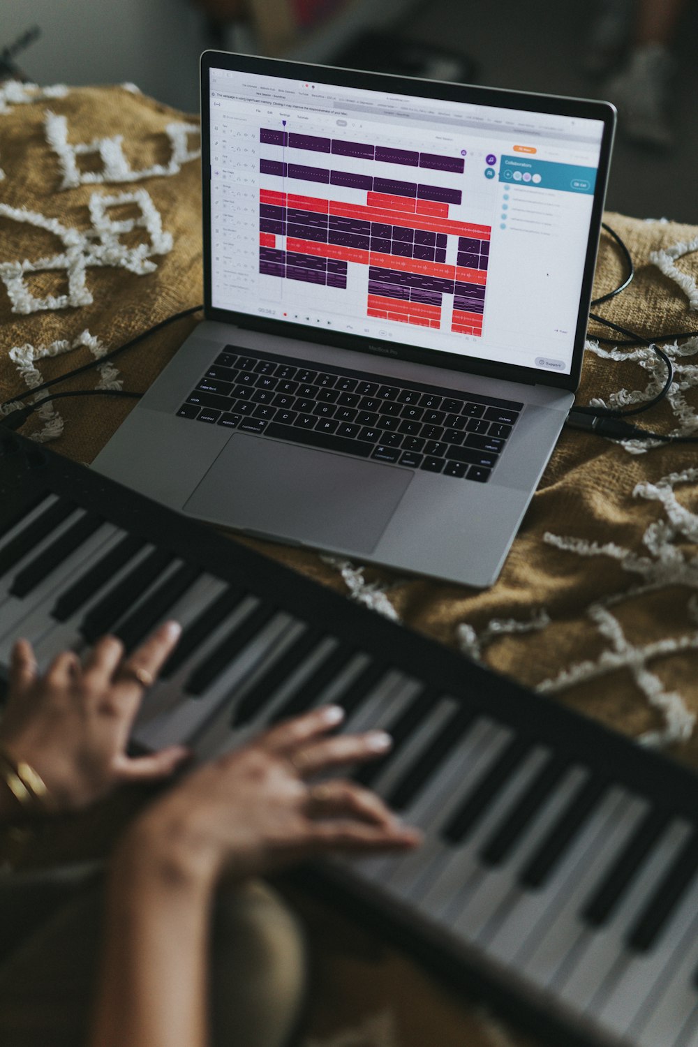 person using macbook air on brown and white textile