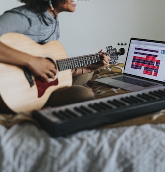 man in gray t-shirt playing guitar