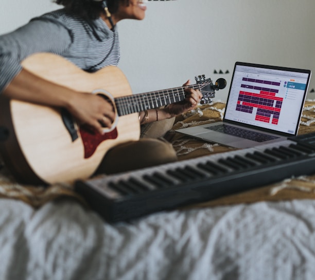 man in gray t-shirt playing guitar