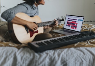 man in gray t-shirt playing guitar