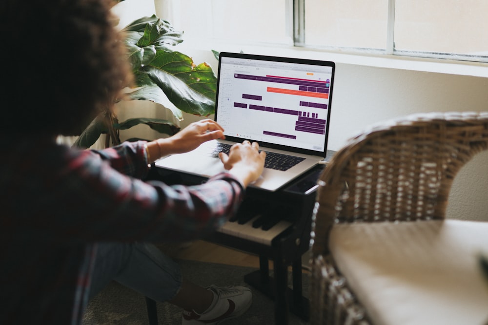 woman in black and pink jacket using silver imac