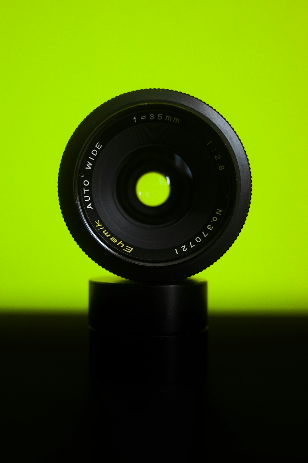 black camera lens on yellow background