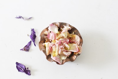 Fresh pollen granules collected in a wooden bowl surrounded by flowers