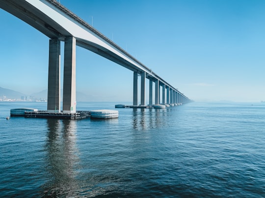 white bridge over blue sea under blue sky during daytime in Rio–Niterói Bridge Brasil