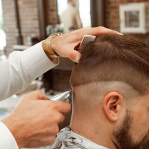 man in white dress shirt cutting hair of man