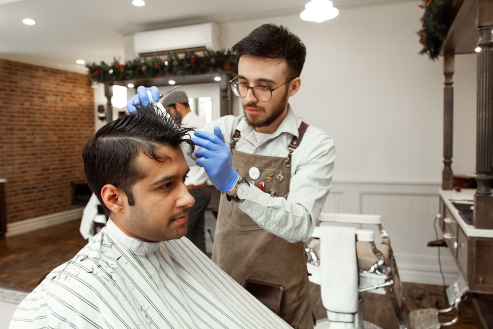 man in white dress shirt cutting hair of man in white dress shirt