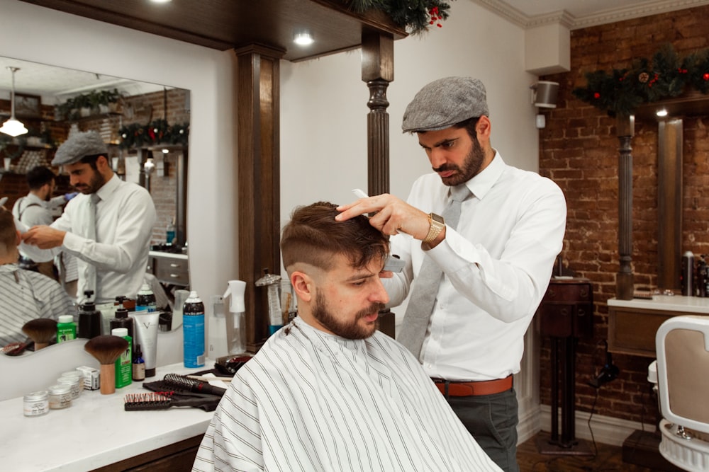 man in white dress shirt cutting hair of man