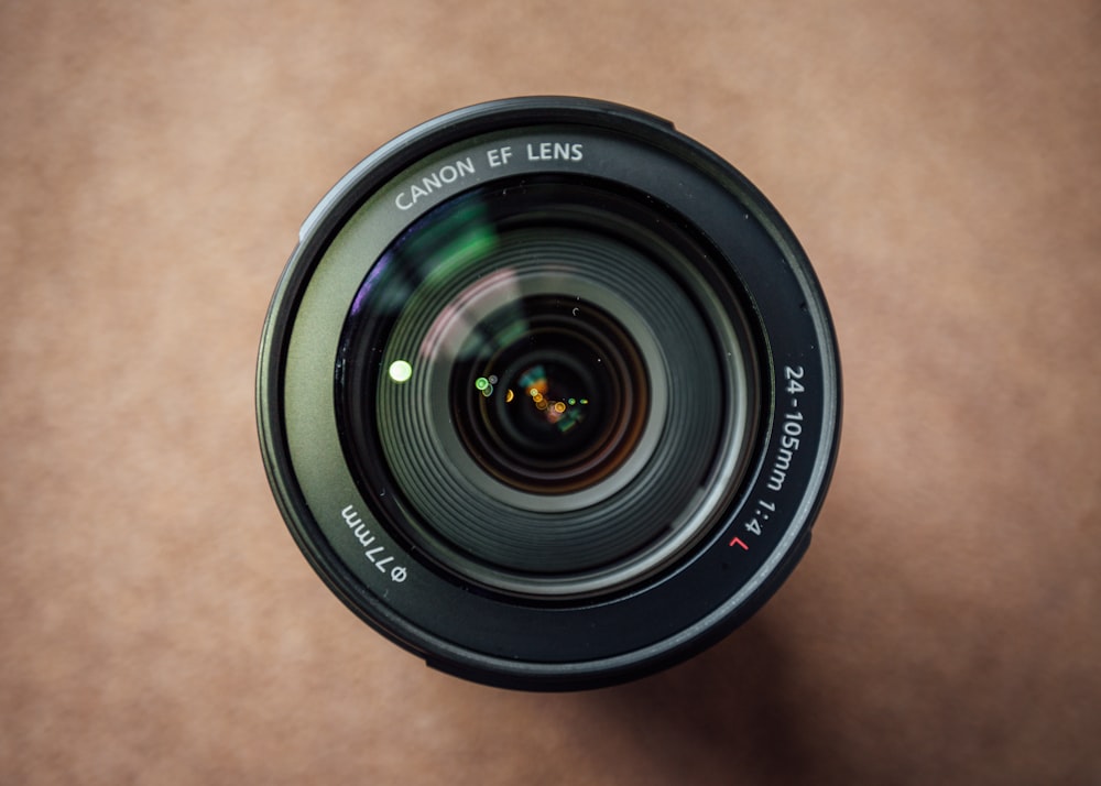 lente da câmera preta na mesa de madeira marrom