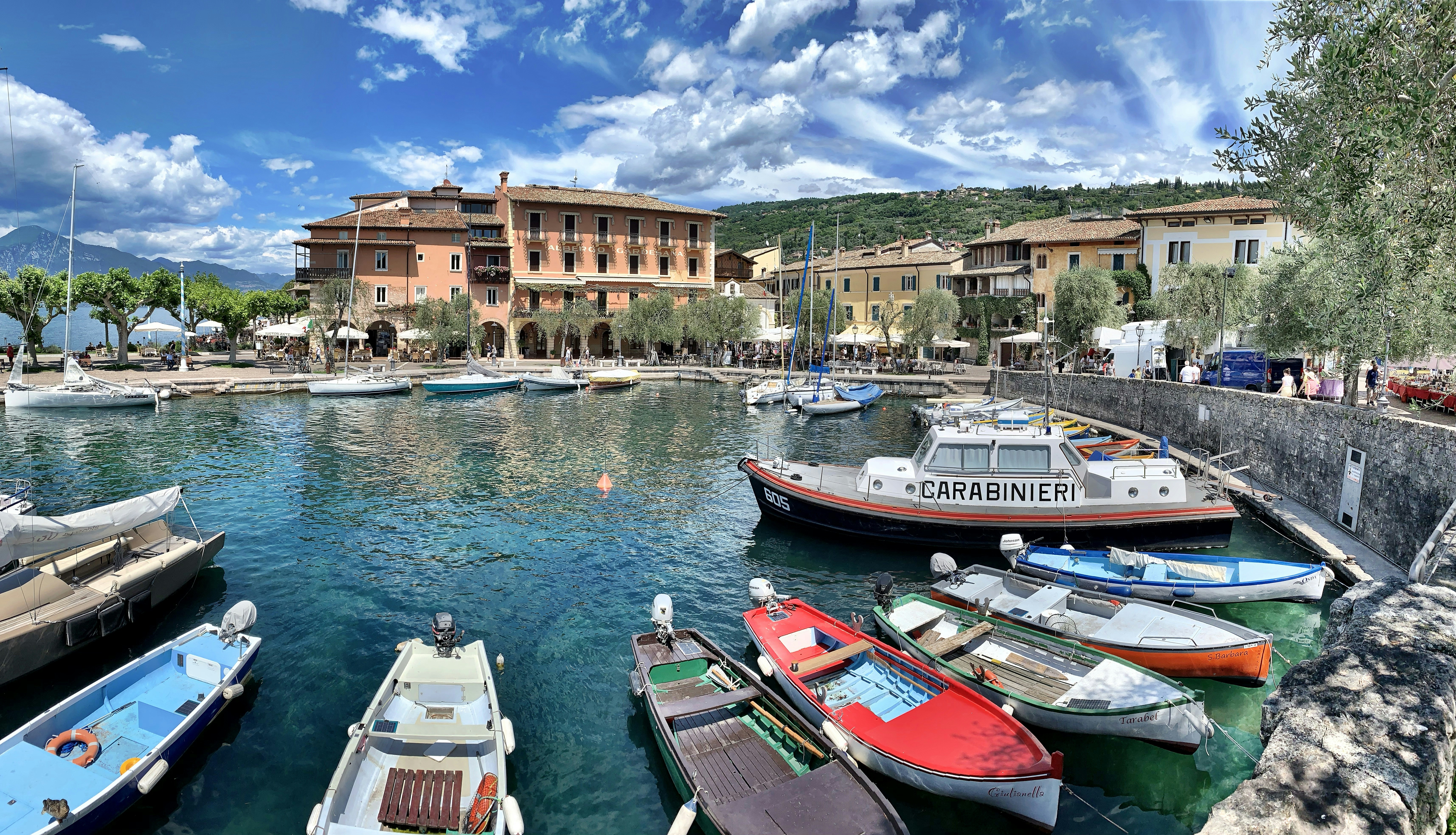 red and white boat on dock near brown concrete building during daytime