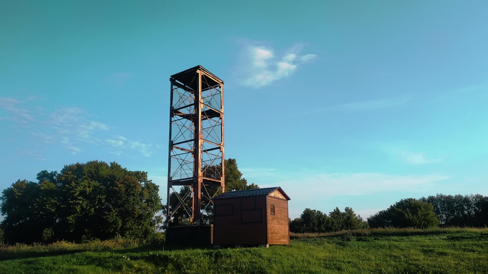 brown wooden house on green grass field under blue sky during daytime