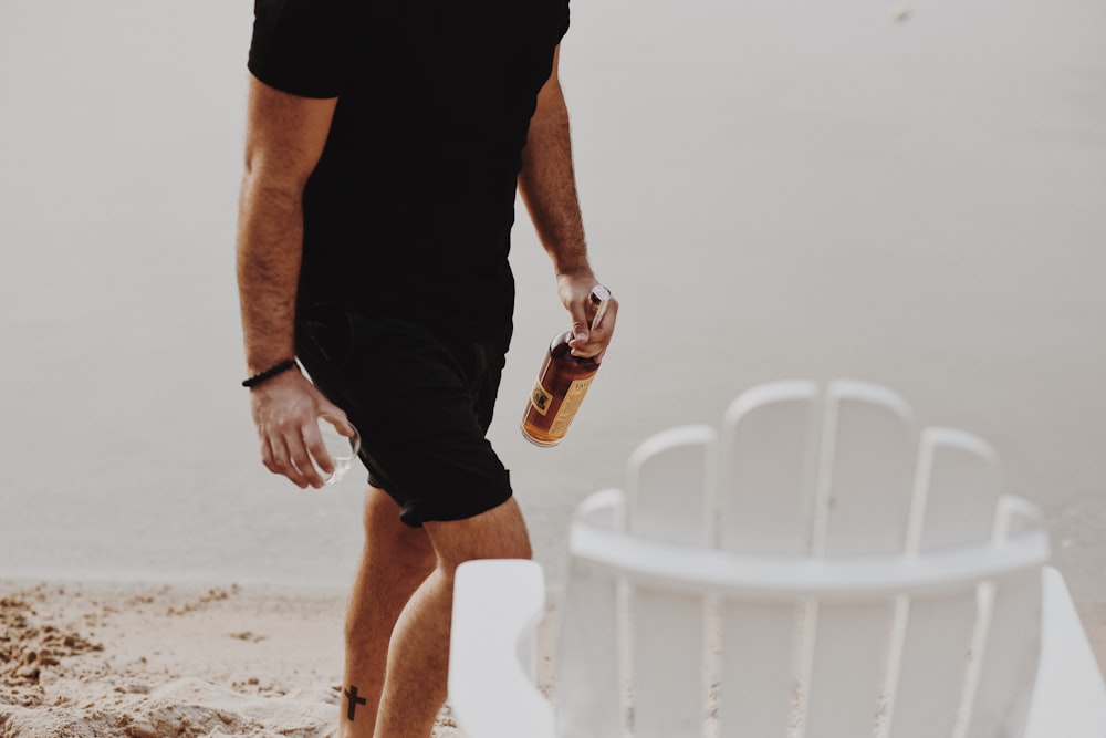 man in black t-shirt and black shorts holding bottle
