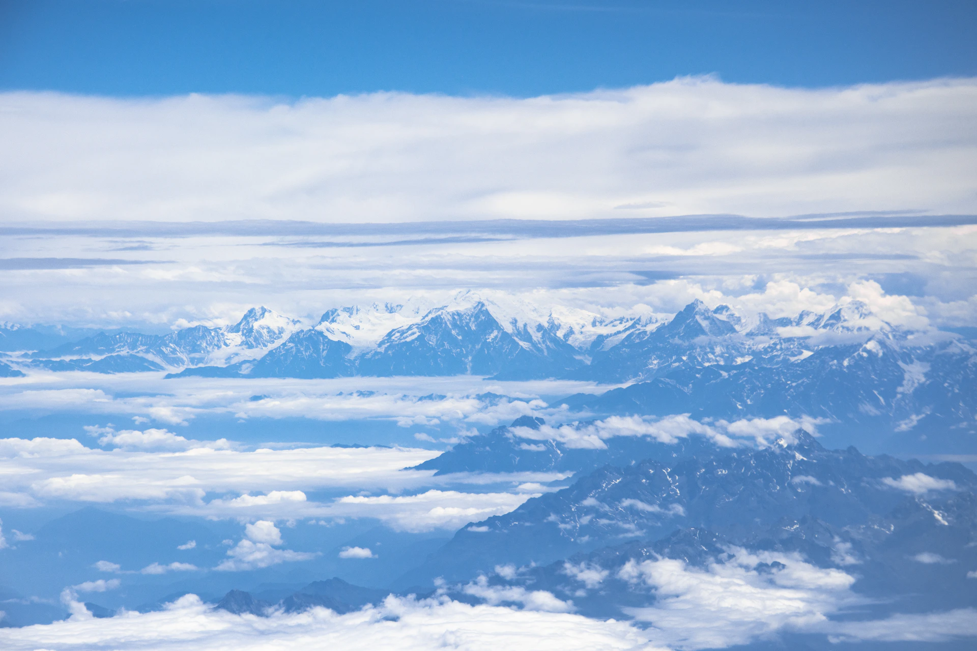 snow covered mountains under white clouds during daytime