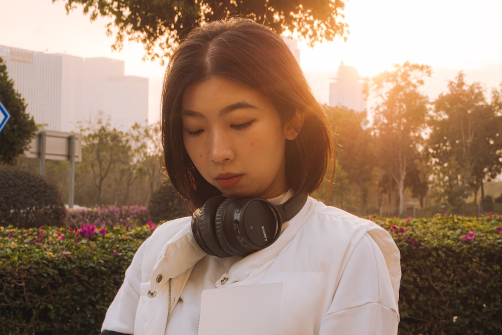 woman in white button up shirt wearing black headphones