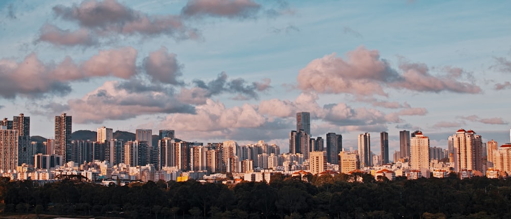 city skyline under white clouds and blue sky during daytime