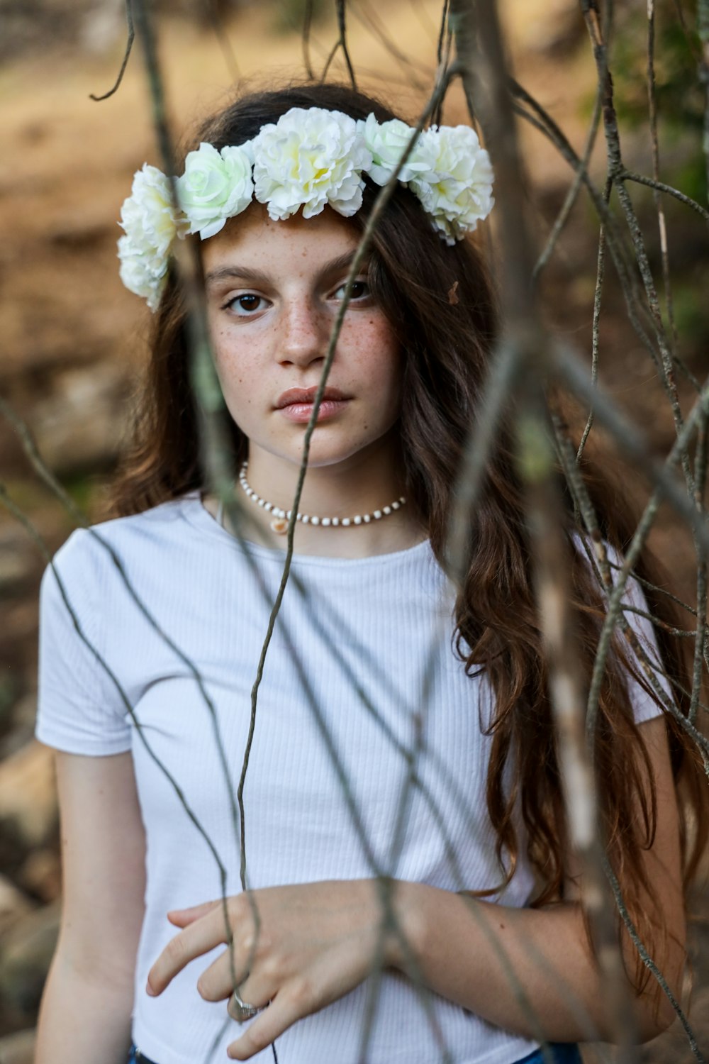 woman in white crew neck t-shirt with white flower on head