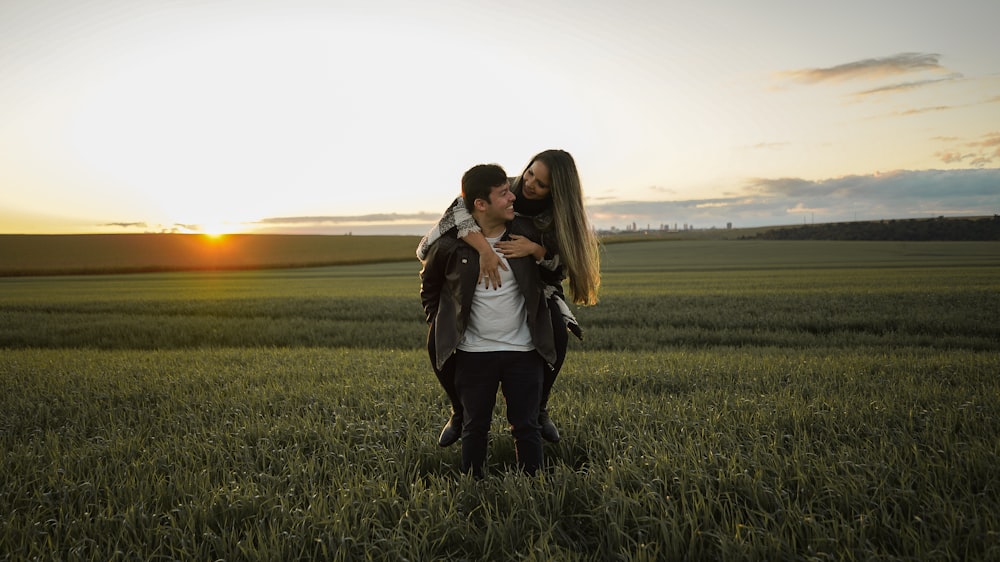 2 femmes debout sur le champ d’herbe verte au coucher du soleil