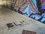 A colorful mural celebrating Black culture painted on an urban building wall.