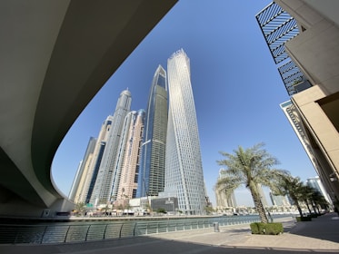 white and gray concrete building near green trees under blue sky during daytime