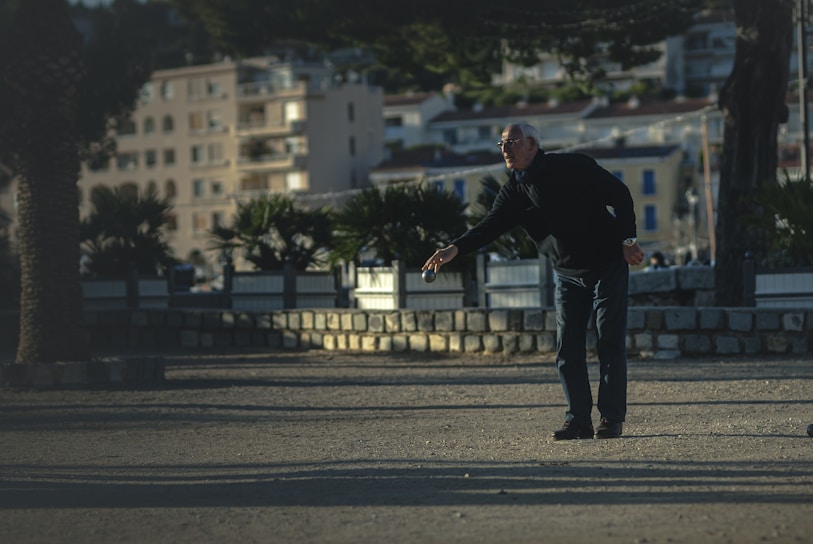 A lively pétanque match in progress with players aiming carefully on a sunny day.