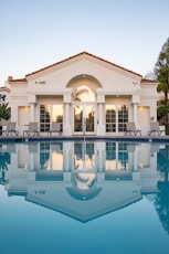 white and brown concrete building near swimming pool during daytime