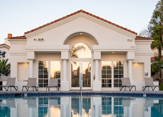 white and brown concrete building near swimming pool during daytime