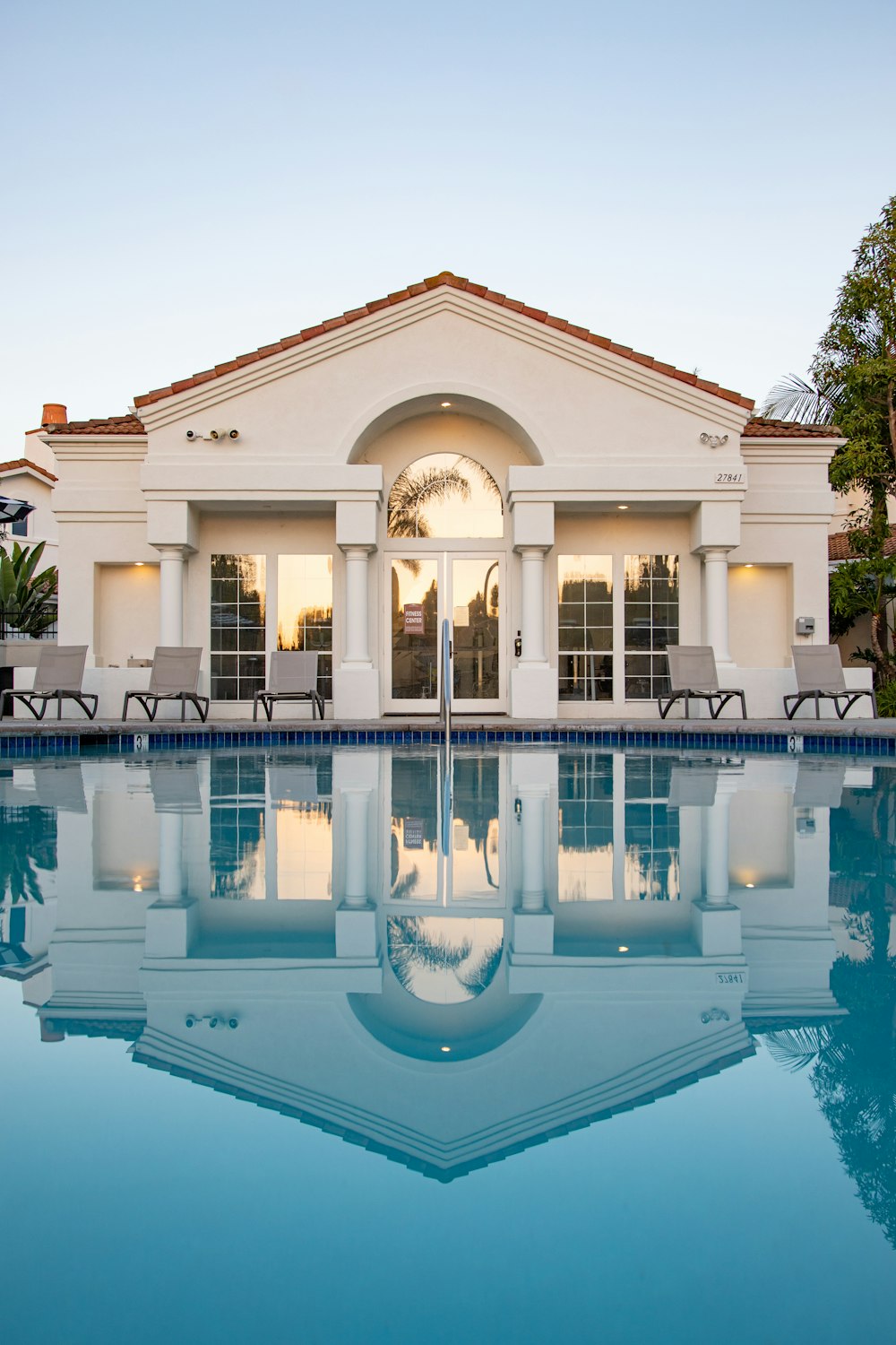 white and brown concrete building near swimming pool during daytime