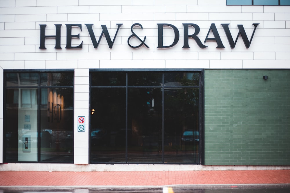 the front of a building with a sign that says hew & draw
