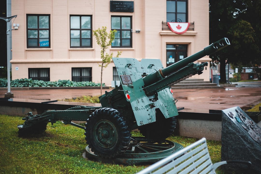 black and gray battle tank on green grass field near brown concrete building during daytime