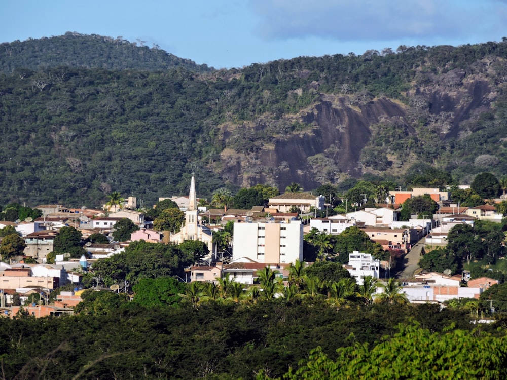 Edificios de hormigón blanco y marrón cerca de Green Mountain bajo el cielo azul durante el día