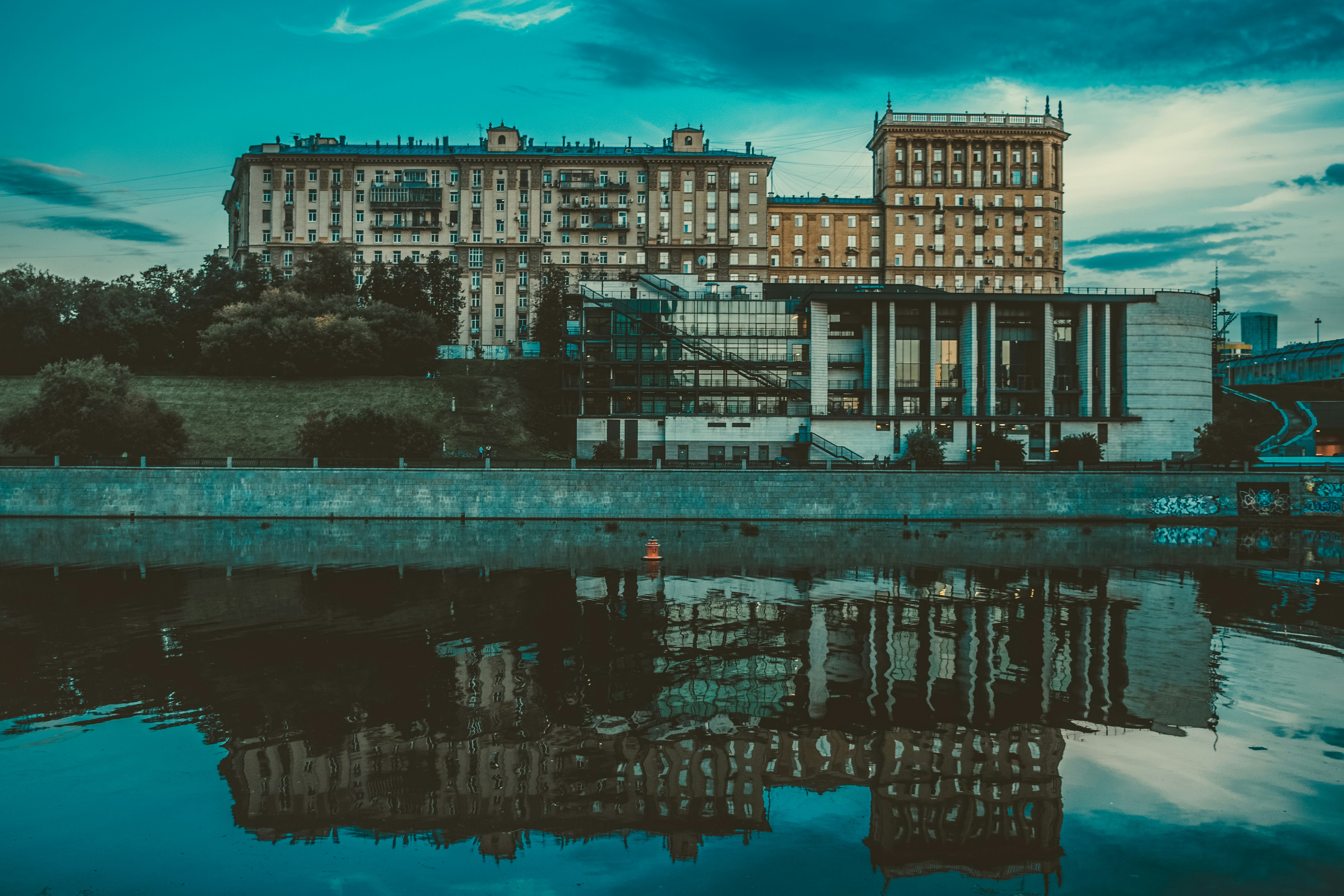 Bâtiment en béton brun près d’un plan d’eau pendant la journée