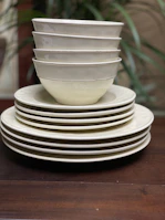 Stacked plates and bowls showcasing the minimalist design and subtle textures of auramesa tableware.