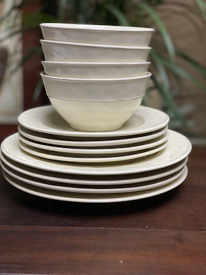 Stacked plates and bowls showcasing the minimalist design and subtle textures of auramesa tableware.